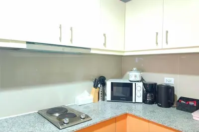 a kitchen with a counter top with a microwave at Cosy BGC Uptown Parksuites with Nice Balcony City View and Ultra Fast Internet 300mbps in Manila