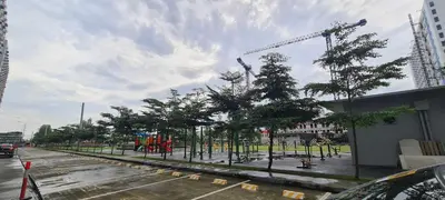 a park with trees and a crane in a city at Arveelene Bedspacing in Manila