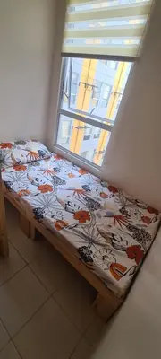 a bed sitting under a window in a room at Arveelene Bedspacing in Manila