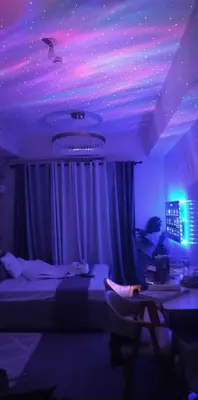 a bedroom with a bed and purple lights on the ceiling at Grace Residences Elevate Escapes - near BGC airport in Manila