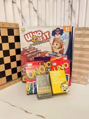 a pile of games on a table next to a boardgame at Grace Residences Elevate Escapes - near BGC airport in Manila