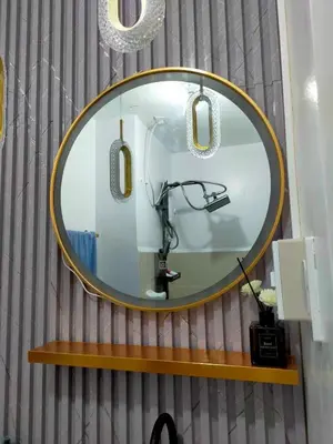 a round mirror on a shelf in a bathroom at Grace Residences Elevate Escapes - near BGC airport in Manila