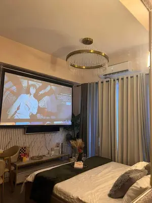 a bedroom with a large screen in the wall at Grace Residences Elevate Escapes - near BGC airport in Manila