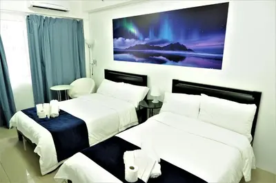 two beds in a room with a painting on the wall at Mall of Asia Shore Dynastel Staycation in Manila