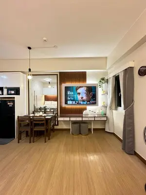 a kitchen and living room with a table and a tv at Davids Suite at Hope Residences Trece Martires Cavite in Trece Martires