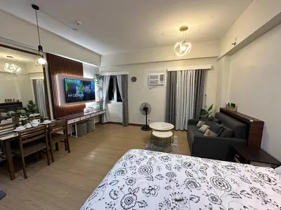 a hotel room with a bed and a living room at Davids Suite at Hope Residences Trece Martires Cavite in Trece Martires