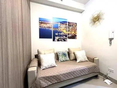 a couch in a room with a picture on the wall at Shore Residences MOA Dynastel Staycation in Manila