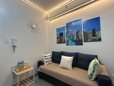 a living room with a couch and pictures on the wall at Shore Residences MOA Dynastel Staycation in Manila
