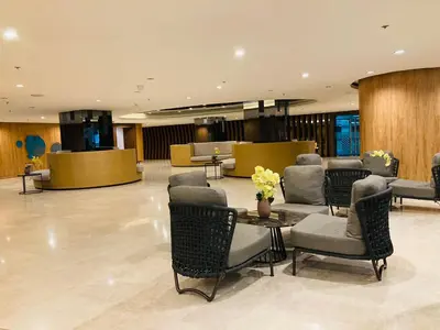 a lobby with chairs and a table with flowers on it at Shore Residences MOA Dynastel Staycation in Manila