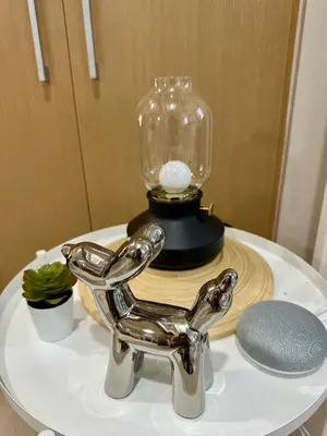 a silver cat statue on a table with a glass jar at 1BR BGC Uptown Modern Condo Netflix 200Mb Wifi in Manila