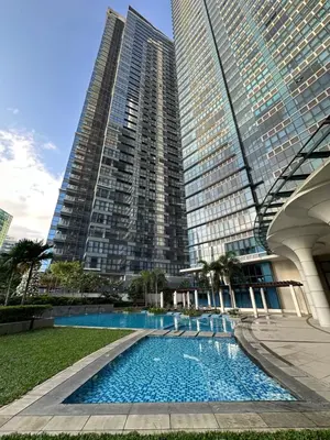 a swimming pool in front of some tall buildings at 1BR BGC Uptown Modern Condo Netflix 200Mb Wifi in Manila