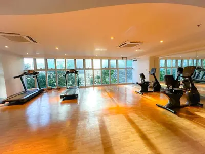 a gym with treadmills and ellipticals in a room at 1BR BGC Uptown Modern Condo Netflix 200Mb Wifi in Manila