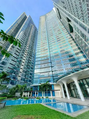 two tall buildings with a pool in front of them at 1BR BGC Uptown Modern Condo Netflix 200Mb Wifi in Manila