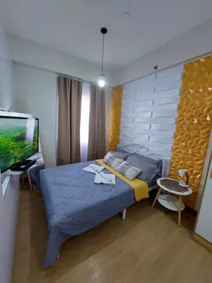 a bedroom with a bed and a flat screen tv at Sojourn at SMDC Hope Residences in Trece Martires