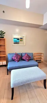 a blue couch sitting in a living room at Eastwood LeGrand 3 Cozy & Modern Studio Type Condominium in Manila