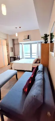 a large room with two beds and a couch in it at Eastwood LeGrand 3 Cozy & Modern Studio Type Condominium in Manila