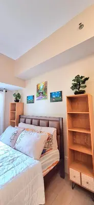 a bedroom with a bed and a shelf at Eastwood LeGrand 3 Cozy & Modern Studio Type Condominium in Manila