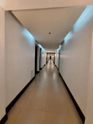 a long corridor with white walls and a long hallway at Eastwood LeGrand 3 Cozy & Modern Studio Type Condominium in Manila
