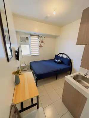 a small room with a blue bed and a sink at Hassle Free Check In and Out With Unli WiFi Netflix in Manila