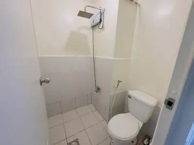 a small bathroom with a toilet and a shower at Hassle Free Check In and Out With Unli WiFi Netflix in Manila