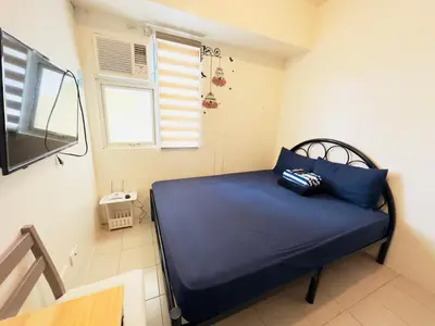 a blue bed in a room with a window at Hassle Free Check In and Out With Unli WiFi Netflix in Manila