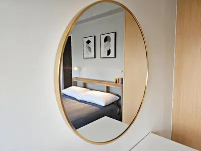 a round mirror in a room with a bed and a bed at Stylish and Spacious Studio Unit in Makati with Fast Wi-Fi in Manila