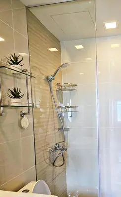 a bathroom with a shower with a glass door at Stylish and Spacious Studio Unit in Makati with Fast Wi-Fi in Manila