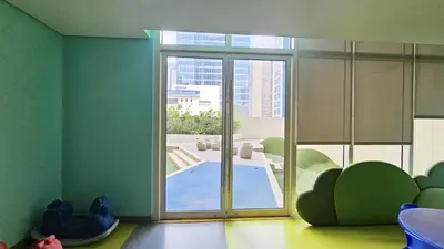 a room with a large glass door with a swimming pool at Stylish and Spacious Studio Unit in Makati with Fast Wi-Fi in Manila