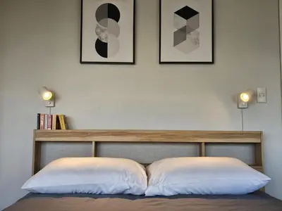 a bed with two pillows and two pictures on the wall at Stylish and Spacious Studio Unit in Makati with Fast Wi-Fi in Manila