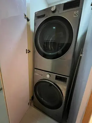a washer and dryer in a small room at Hotel Vibe Condo at Uptown Parksuites BGC in Manila