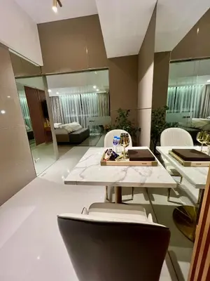 a living room with a table and chairs and a room at Hotel Vibe Condo at Uptown Parksuites BGC in Manila