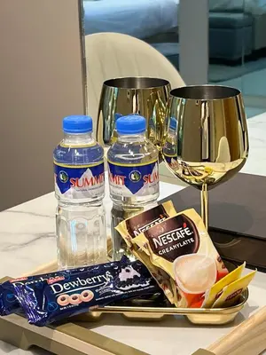 a tray with two bottles of water and snacks on a table at Hotel Vibe Condo at Uptown Parksuites BGC in Manila