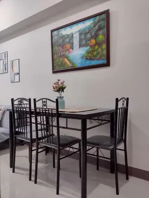 a dining room table with chairs and a painting on the wall at G&M Comfy place for your stay at SMDC Coast Residences in Manila