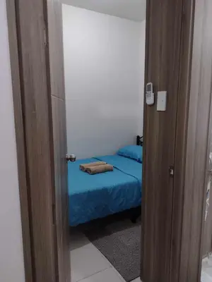a small room with a small bed with a blue blanket at G&M Comfy place for your stay at SMDC Coast Residences in Manila