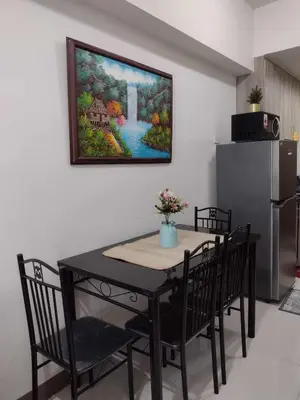 a dining room table with chairs and a painting on the wall at G&M Comfy place for your stay at SMDC Coast Residences in Manila
