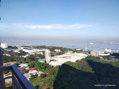 a view of a city and the ocean from a balcony at G&M Comfy place for your stay at SMDC Coast Residences in Manila