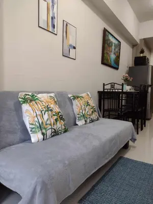 a gray couch with pillows in a living room at G&M Comfy place for your stay at SMDC Coast Residences in Manila
