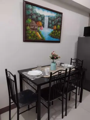 a dining room table with chairs and a painting on the wall at G&M Comfy place for your stay at SMDC Coast Residences in Manila
