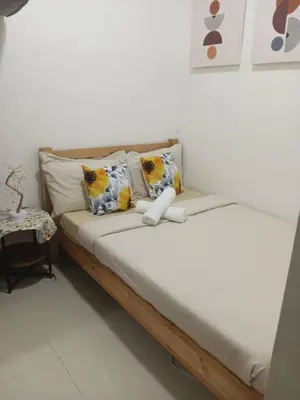 a bed with two pillows and a stuffed animal on it at Cozy 1BR w/Wifi&Netflix in FAME near Shaw MRT in Manila