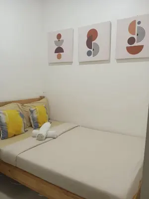 a bed in a room with pictures on the wall at Cozy 1BR w/Wifi&Netflix in FAME near Shaw MRT in Manila