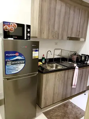 a kitchen with a stainless steel refrigerator and a sink at Cozy 1BR w/Wifi&Netflix in FAME near Shaw MRT in Manila
