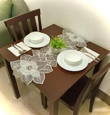 a wooden table with plates and napkins on it at Cozy 1BR w/Wifi&Netflix in FAME near Shaw MRT in Manila