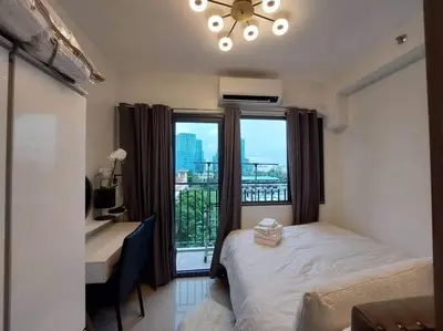 a bedroom with a bed and a desk and a window at Little Lux Condo Shore 2-T3 Improved in Manila