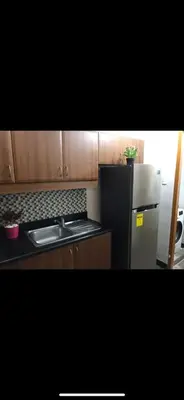 a kitchen with a black refrigerator and a sink at Montecito Luxury 1 bedroom condominium in Manila