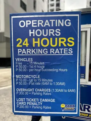 a sign that says operating hours hours parking rates at Stylist Luxe Condo near Mall of Asia - Shore 3 in Manila