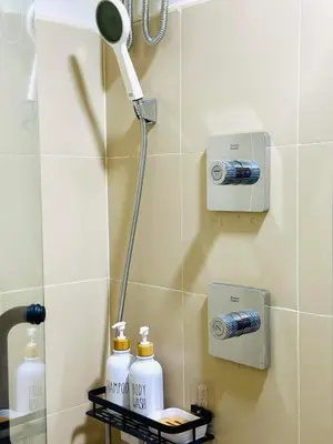 a bathroom with a shower head and bottles of soap at Stylist Luxe Condo near Mall of Asia - Shore 3 in Manila