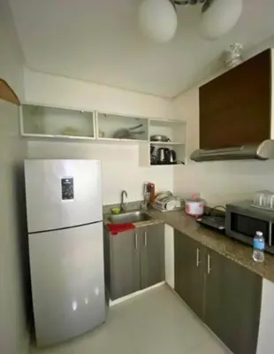 a small kitchen with a refrigerator and a sink at FREE Pool n FREE Sauna Access OceanView Balcony in The Heart of Manila, Front of Robinsons Mall, Walking Distance to US Embassy Limited Slots x Secure Your Limited Offer This Month in Manila