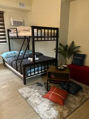 two bunk beds in a room with a rug at Brand New Studio w/ Washer in Manhattan Plaza Tower ll in Manila