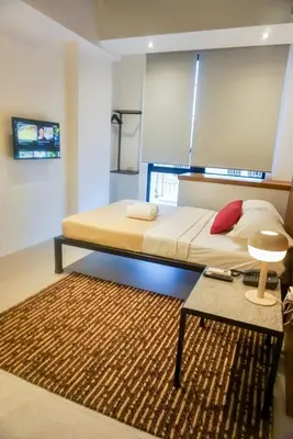 a bedroom with a bed with a rug and a table at Cayco House by Hotel Durban in Manila