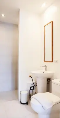 a white bathroom with a sink and a mirror at Cayco House by Hotel Durban in Manila